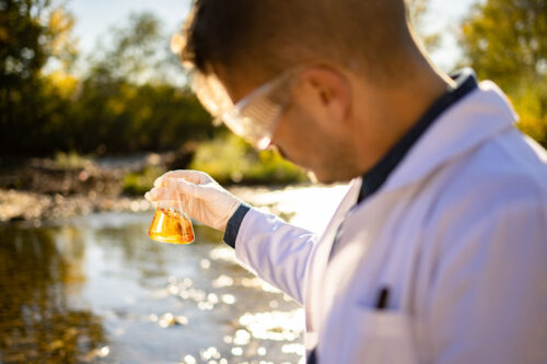 A biological researcher taking a water sample